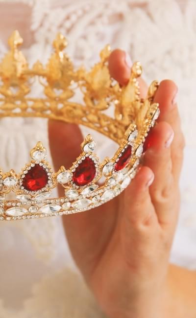 hands holding jeweled crown